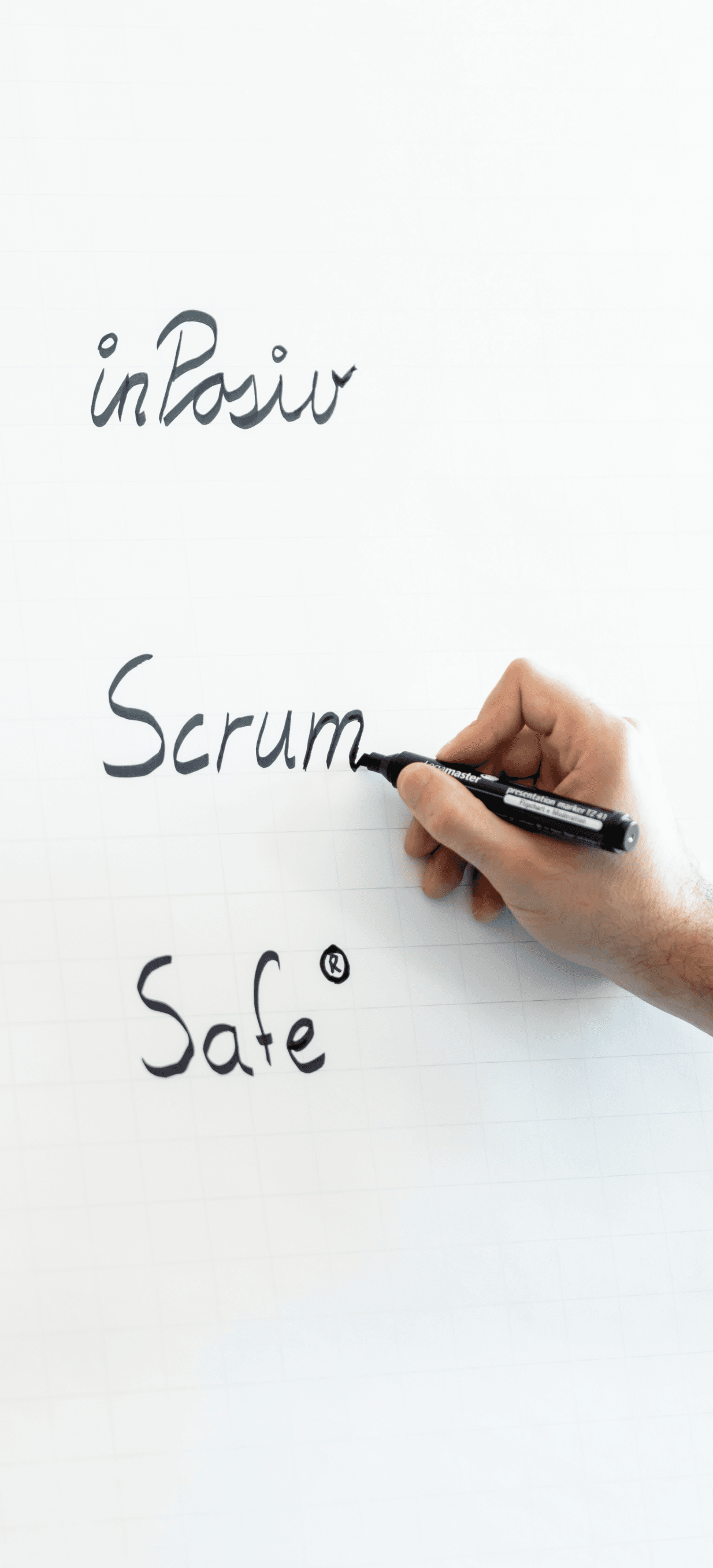 Three words written on the desk: InPositiv, Scrum and SAFe®